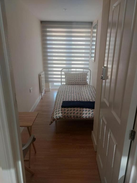a hallway with a bed in a room with a window at Tollgate Drive in Southall