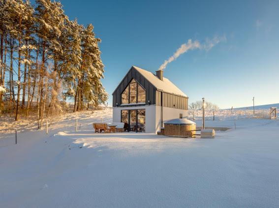 a large building in the middle of a snow covered field at Warmia Forest Kobułty 