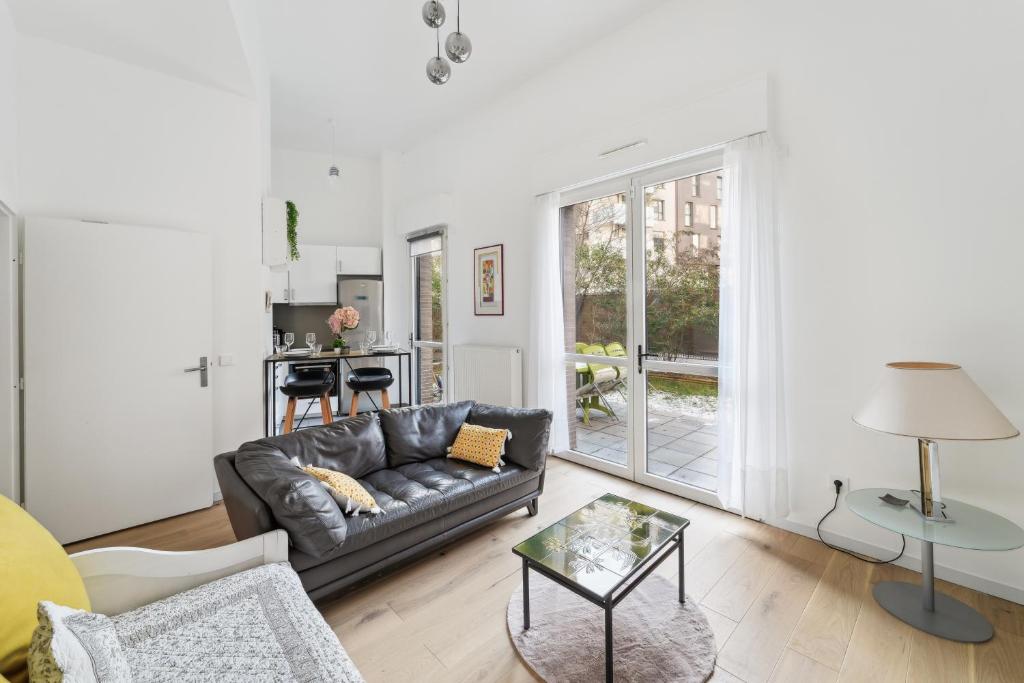 a living room with a couch and a table at Chic apart terrace garden parking in Asnières-sur-Seine
