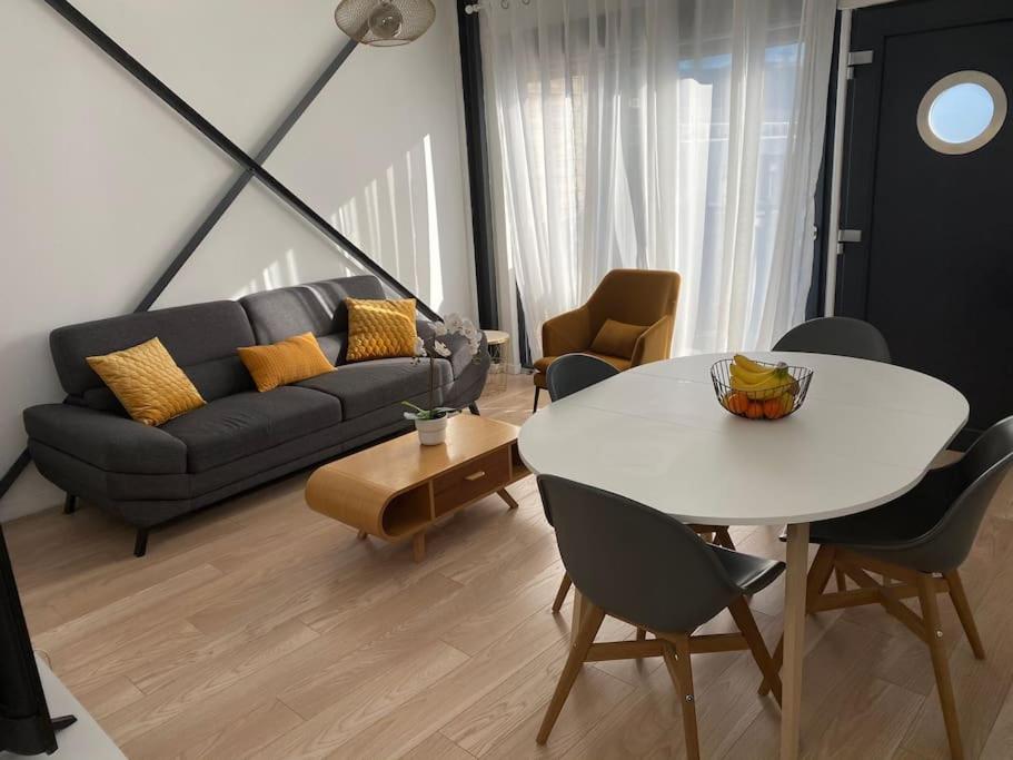 - un salon avec une table blanche et un canapé dans l'établissement Velaux Moderne appart 4 pers - Tout équipé avec terrasse à 15 min plage et aéroport, à Velaux