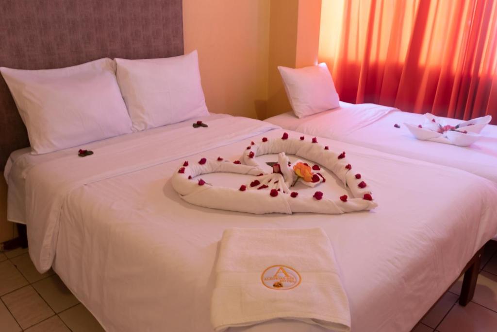 two beds with a valentines heart on the bed at Alegrias Inn Hotel in Cusco