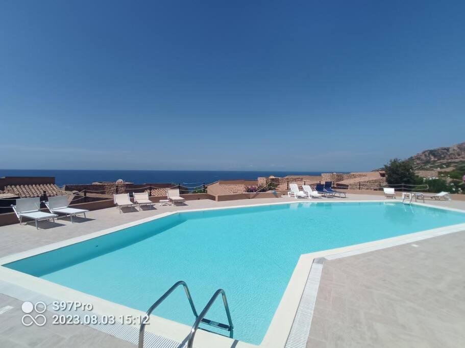a large swimming pool with a view of the ocean at Villetta Isor con piscina in Costa Paradiso