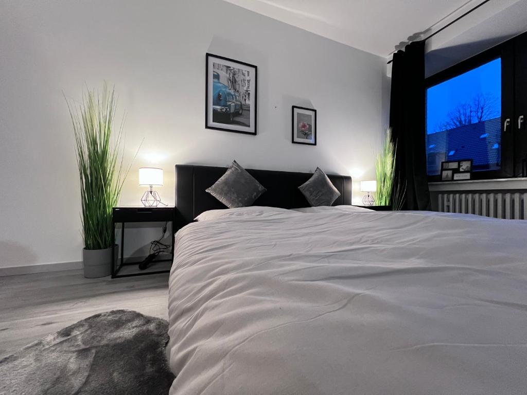 a bedroom with a large bed with a large window at Rü-Premium Apartments in Essen