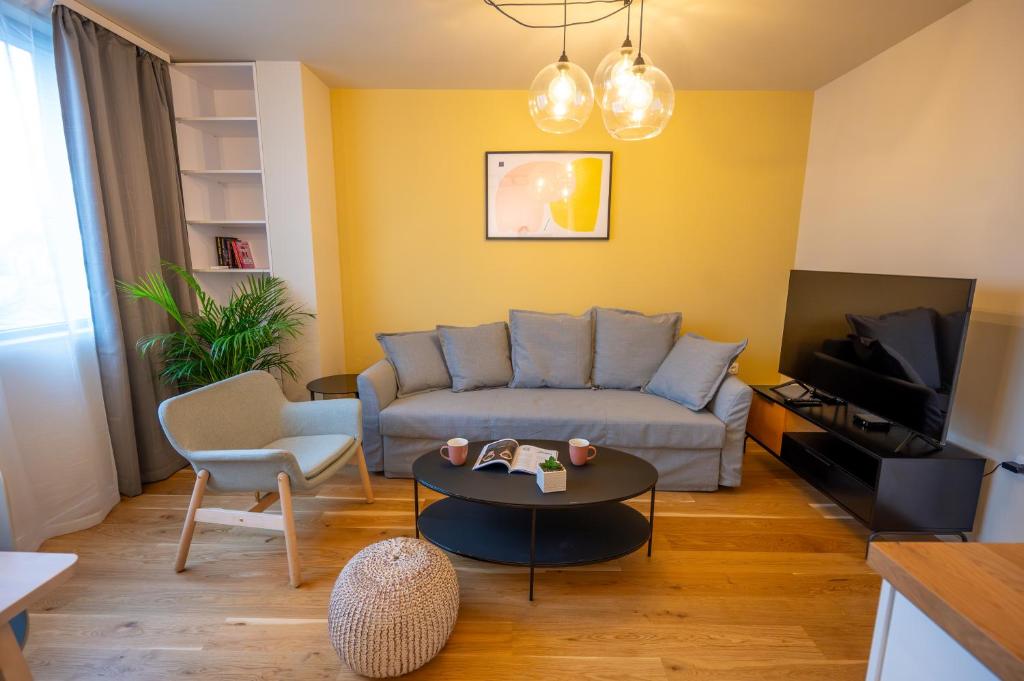 ein Wohnzimmer mit einem Sofa und einem Tisch in der Unterkunft Design 1BDR Apartment near City Center in Sofia