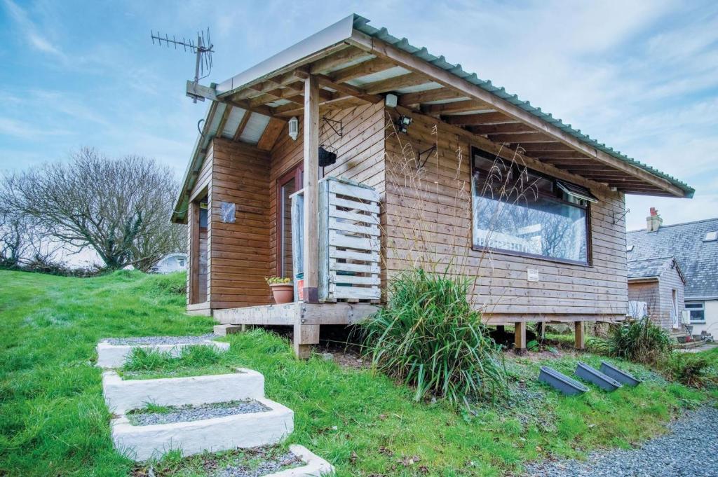 una pequeña casa de madera con porche y escaleras en The Hygge Hut - 1 Bed - Freshwest Beach Retreat en Pembroke
