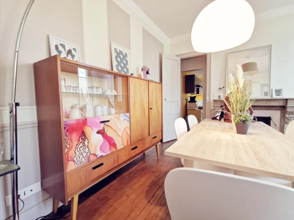une salle à manger avec une table et une armoire en verre dans l'établissement Maison Vanier - Duplex - centre-ville - Mon Groom, à Troyes