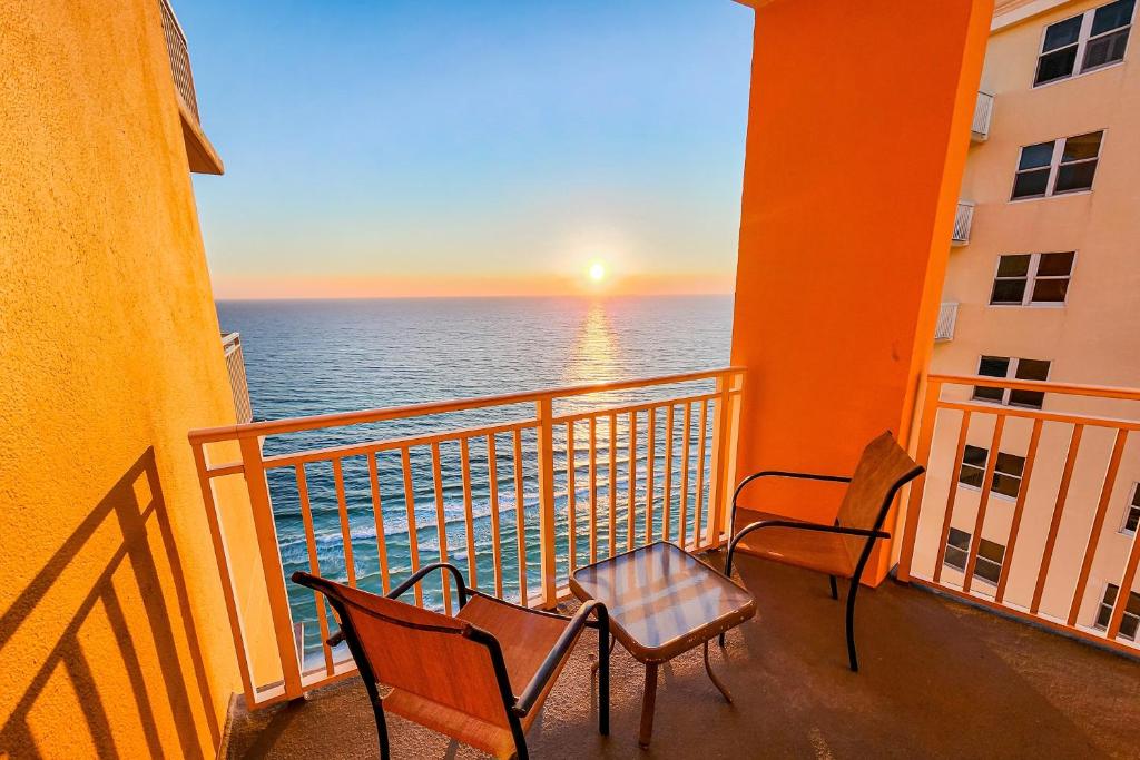 two chairs and a table on a balcony with the ocean at Splash Resort 1901W Suite A Studio in Panama City Beach