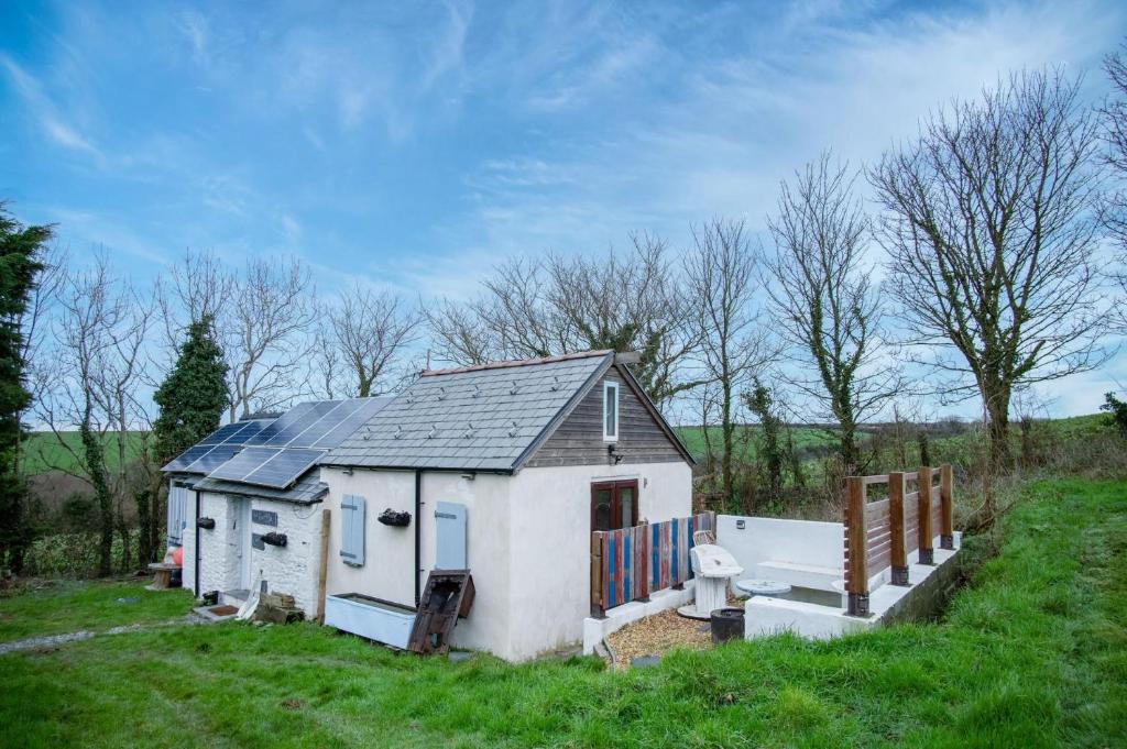 a small house with a solar roof in a field at The Anchor Light - 1 Bed - Freshwest Beach Retreat in Pembroke