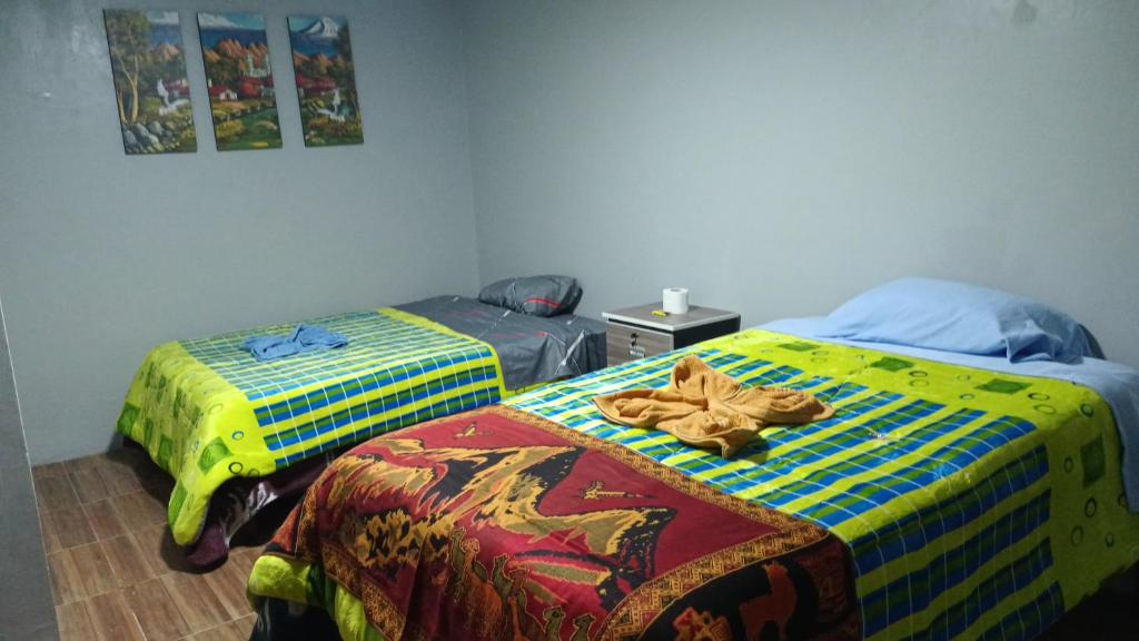 2 Betten nebeneinander in einem Zimmer in der Unterkunft El Amauta de los Andes Lodging Erik House in Huaraz