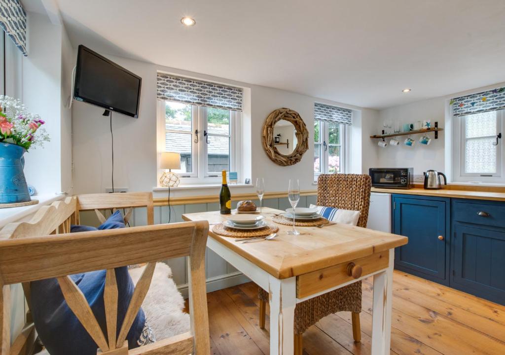 a kitchen with a wooden table and a dining room at Pendeen Hayloft in Saint Stephen