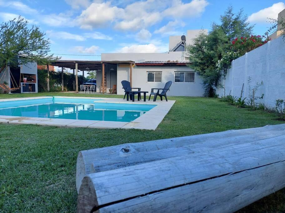 a backyard with a swimming pool and a house at Casa en Funes. Pileta, Parrilla & Parque. in Funes