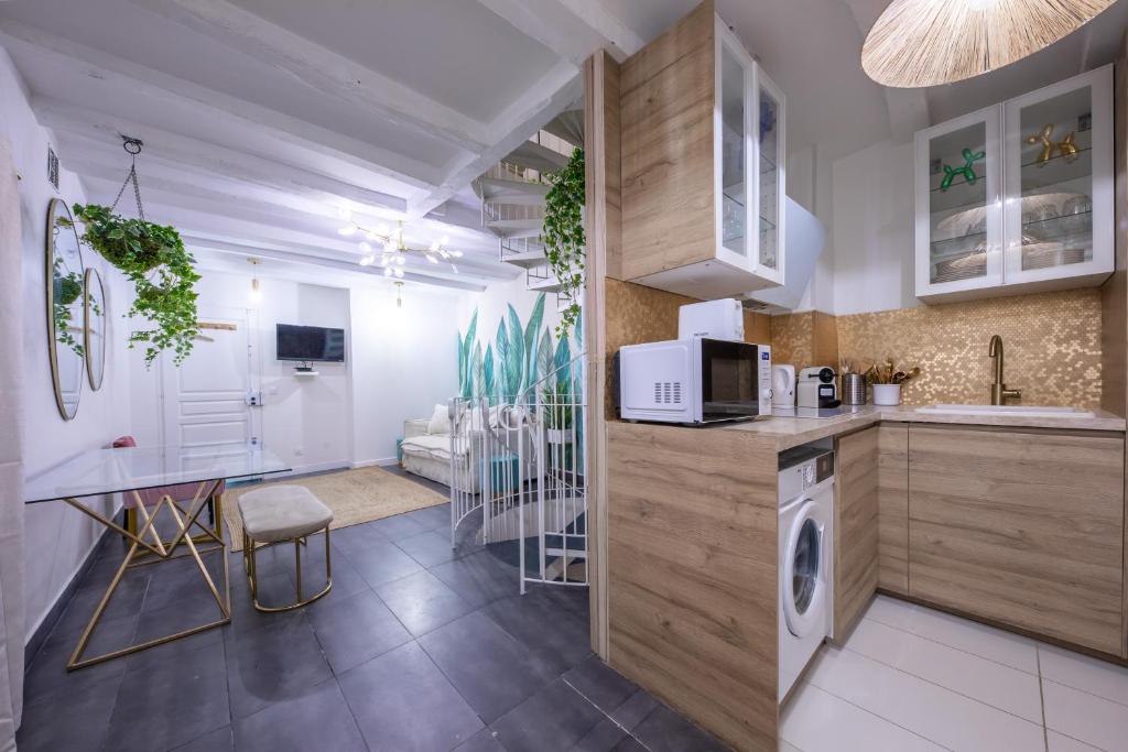 Il comprend une cuisine et un salon avec un évier et une cuisinière. dans l'établissement LOUVRE-MONTORGEUIL PARIS HISTORICAL CENTER, à Paris