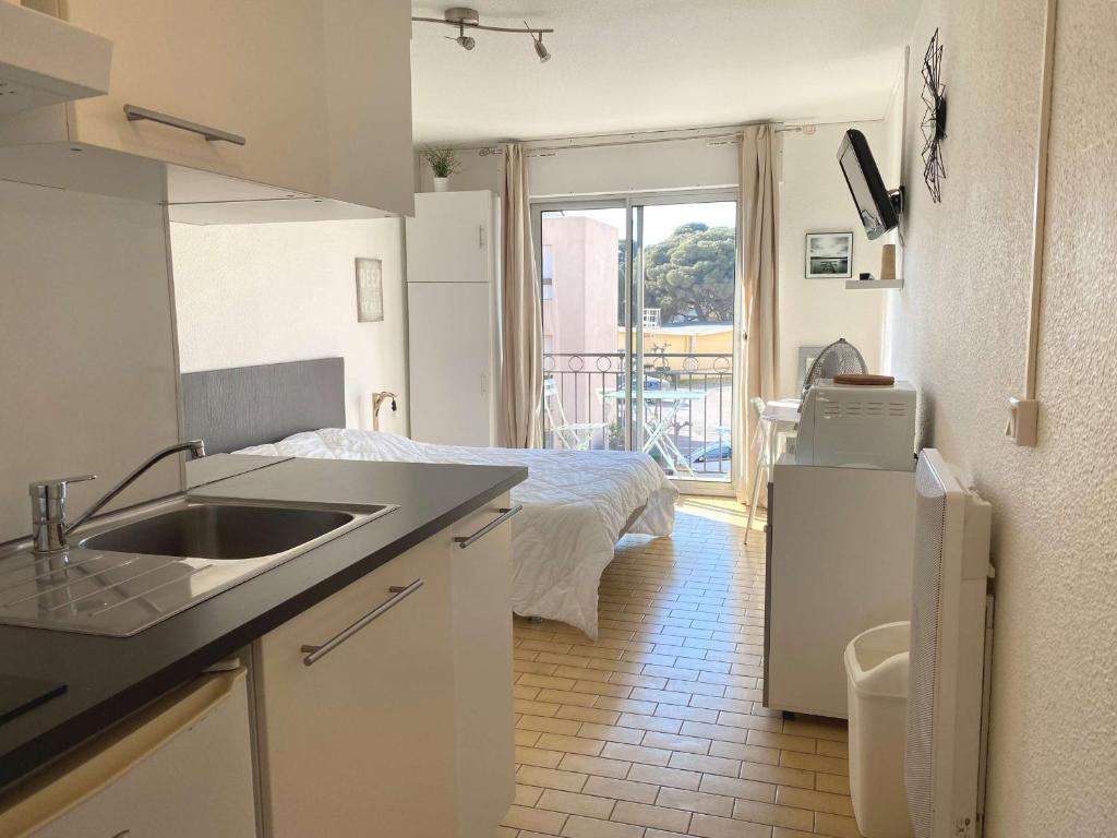 - une cuisine avec évier et un lit dans une chambre dans l'établissement Studio rénové climatisé avec balcon, parking et wifi à Balaruc-les-Bains - FR-1-553-66, à Balaruc-les-Bains