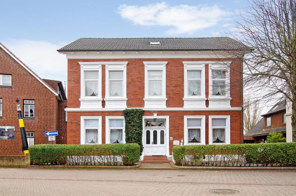 a red brick house with a white door at Villa Harmonie - Apartment Jasmin in Borkum