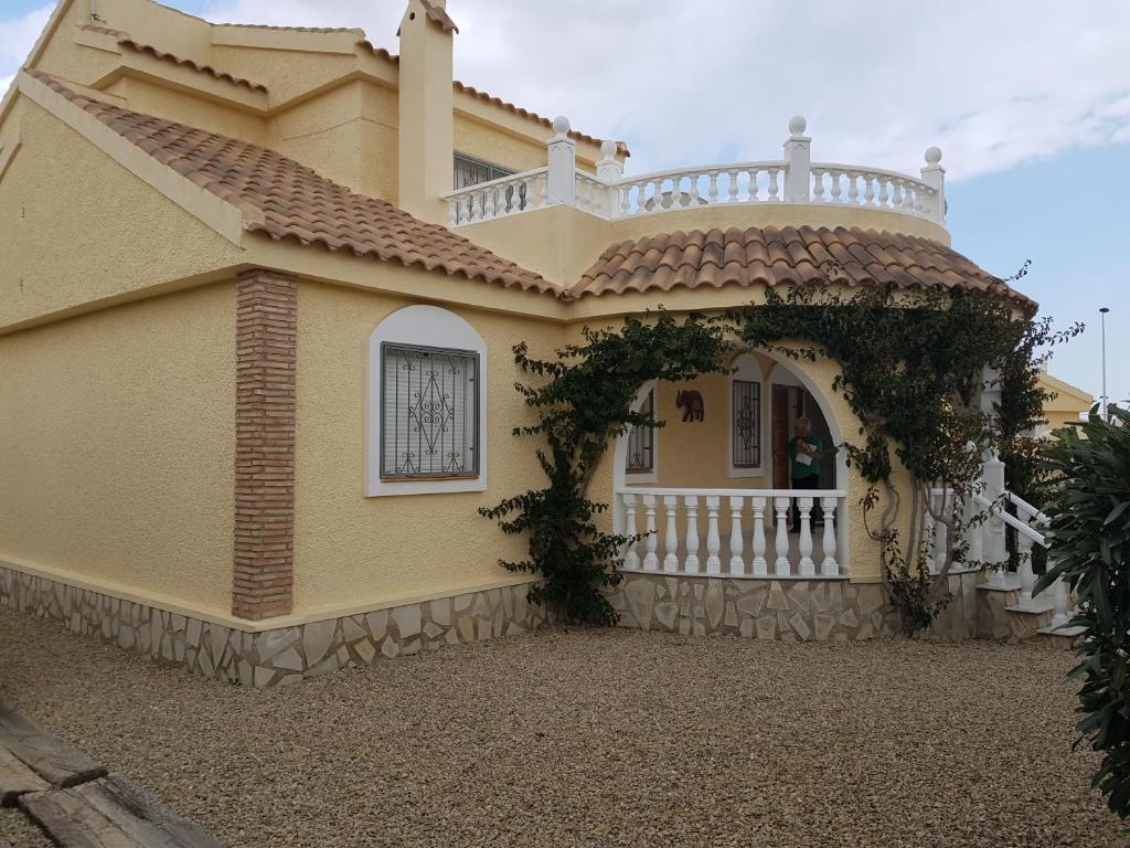 una casa amarilla con una valla blanca y un porche en Relaxing 3 bed 3 bath Villa for 8 Camposol Sect D, en Mazarrón