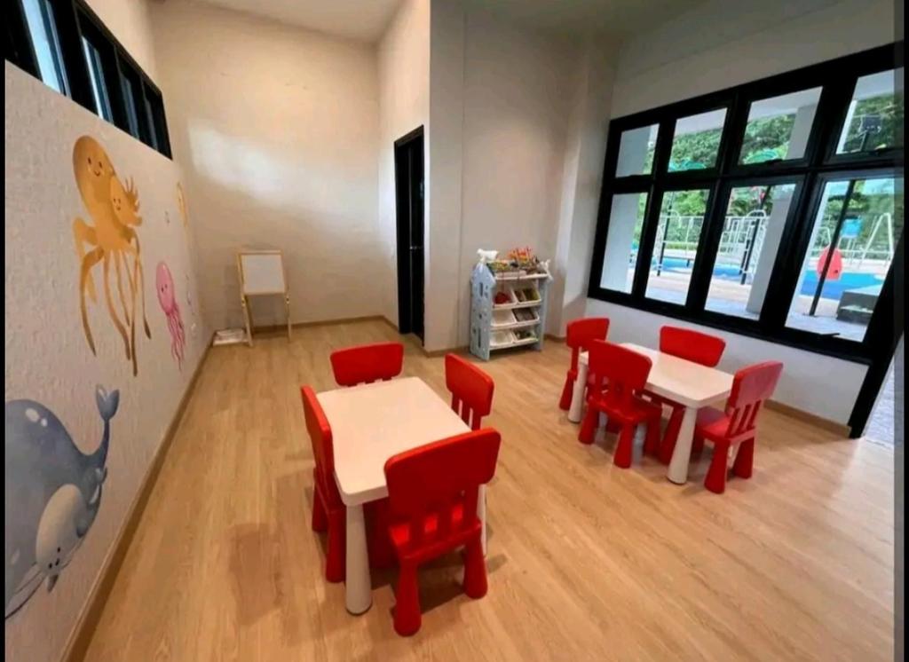 a dining room with red chairs and tables in a room at Mutiara Melaka Beach Resort by Ally in Kampong Pengkalan Lanjut