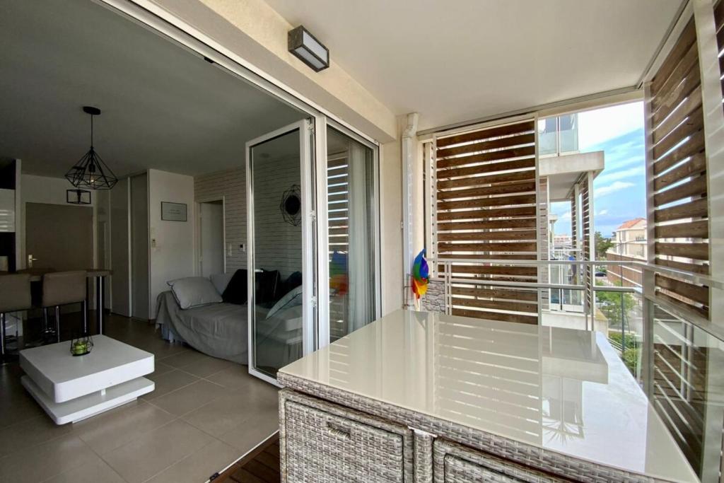 uma cozinha com uma grande janela de vidro e uma sala de estar em Le Terrasse en Mer- Air conditioning parking and seaside! em Palavas-les-Flots