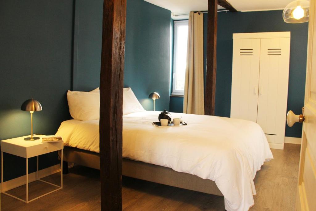 een slaapkamer met een groot bed en een spiegel bij Picassiette in Chartres