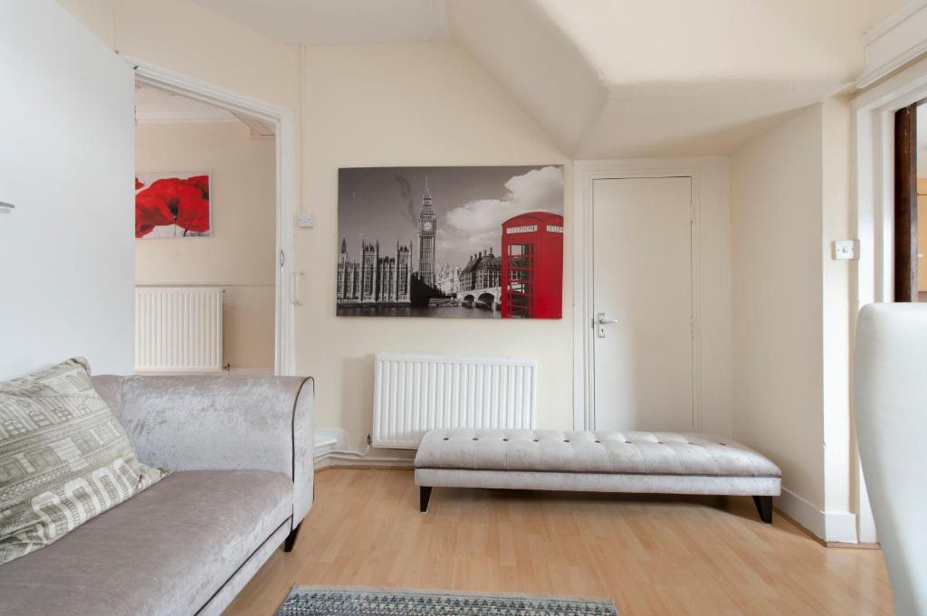 ein Wohnzimmer mit einem Sofa und einer roten Telefonzelle in der Unterkunft 4 BED House IN Dartford 8 Beds Sleeps 10 in Kent