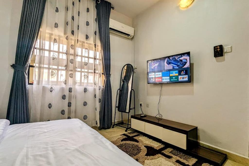 um quarto com uma cama e uma televisão de ecrã plano em The Zen Haven em Uyo