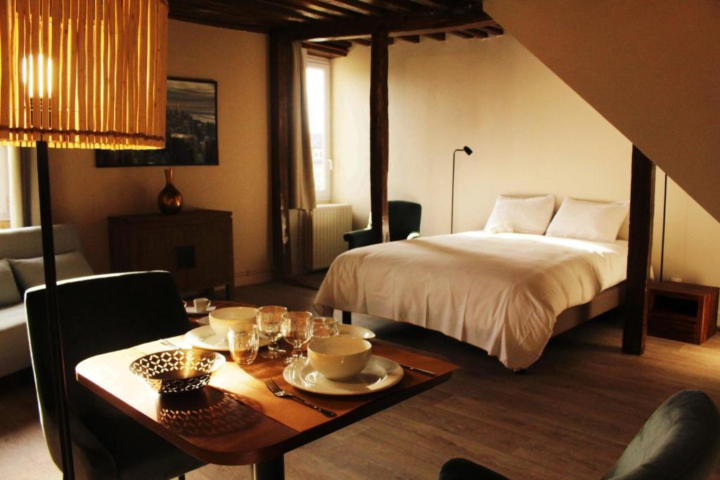 - une chambre avec un lit, une table et une salle à manger dans l'établissement Fulbert - view on Cathedral and Place des Epars, à Chartres