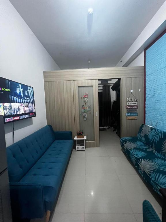 una sala de estar con un sofá azul en una habitación en Shore 1 Residences near Mall of Asia staycation, en Manila