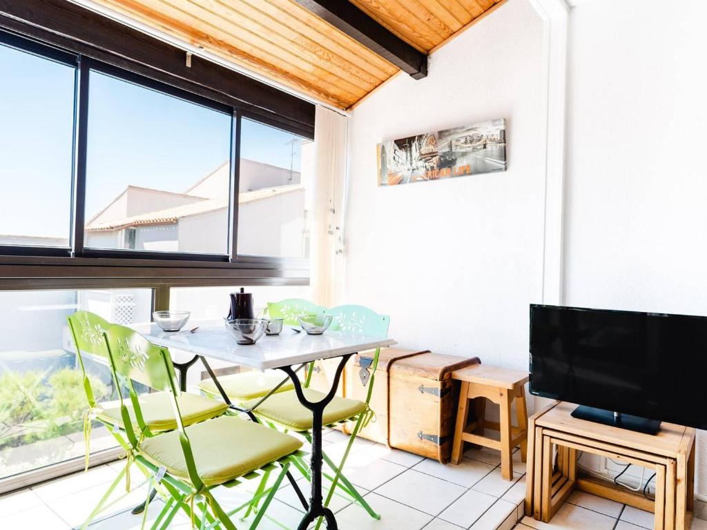 une pièce avec une table, des chaises et une télévision dans l'établissement Appartement T2 Cabine - Front de Mer, Parking Privé, 4 Couchages, Narbonne - FR-1-409-6, à Narbonne-Plage
