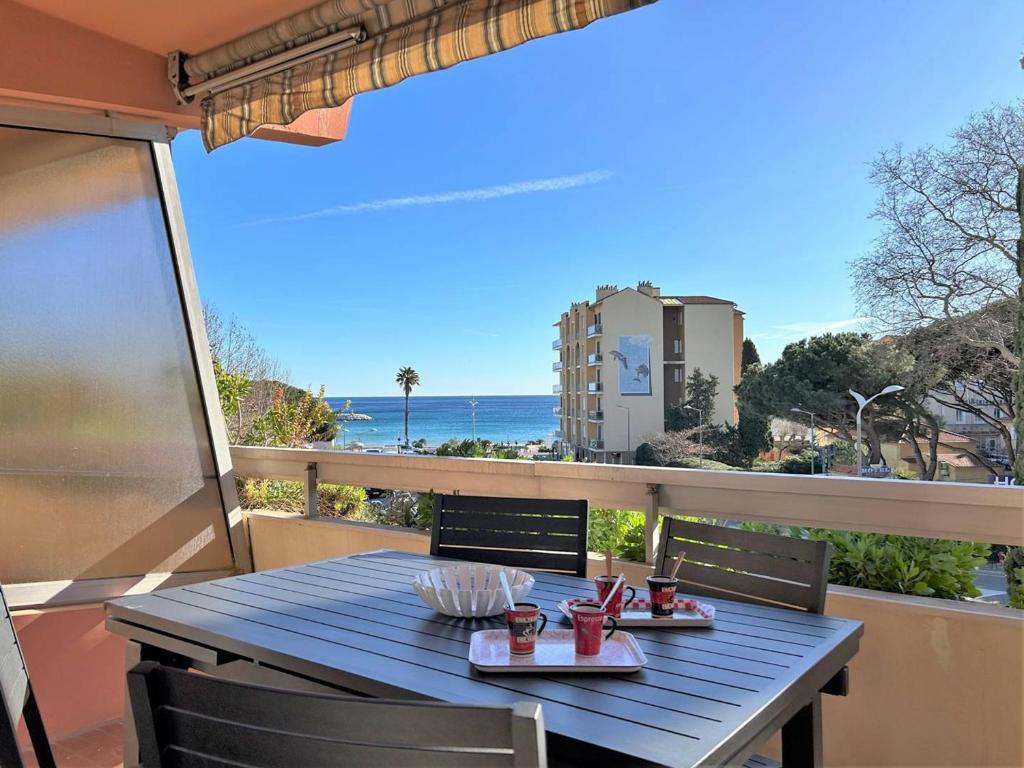 a table on a balcony with a view of the ocean at Appartement 2 pièces, climatisé, 100m plage, parking, Le Lavandou - FR-1-251-218 in Le Lavandou