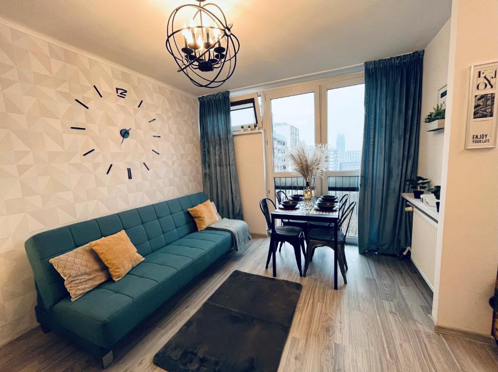 a living room with a couch and a clock on the wall at Apartament z panoramicznym widokiem w Centrum in Warsaw