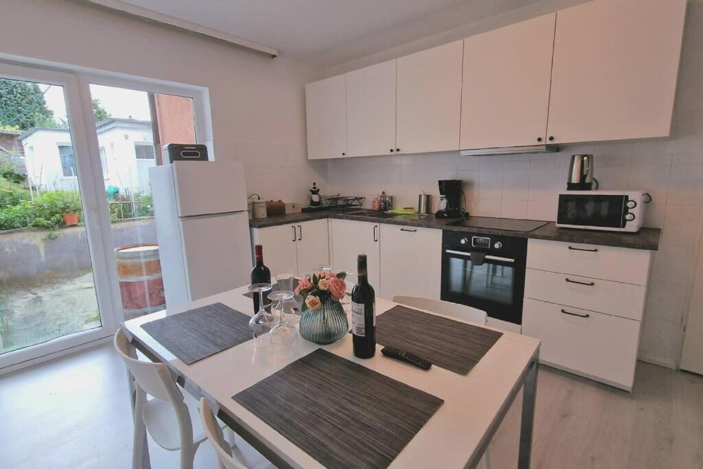 a kitchen with a table with two bottles of wine at Ferienwohnung Best Apartments Leverkusen 1 in Leverkusen