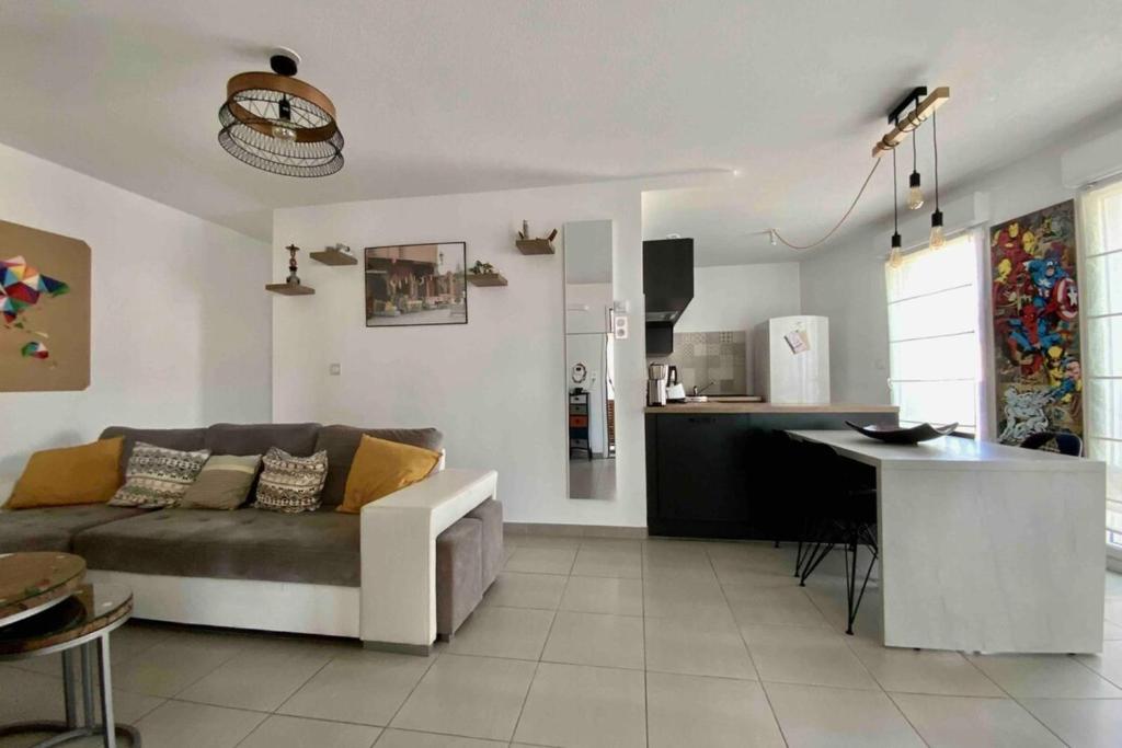 Il comprend un salon et une cuisine avec un canapé et une table. dans l'établissement The Pleasant - Air conditioning terrace and parking!, à Montpellier