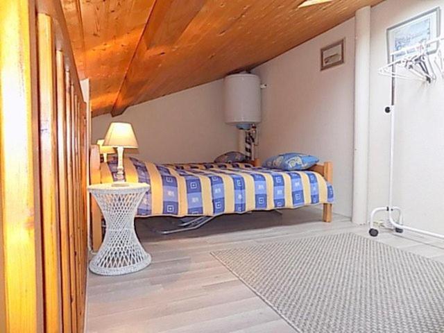 a bedroom with a bed with a table and a lamp at Vaux sur Mer - côté PONTAILLAC - VILLA MITOYENNE - PISCINE COLLECTIVE in Vaux-sur-Mer