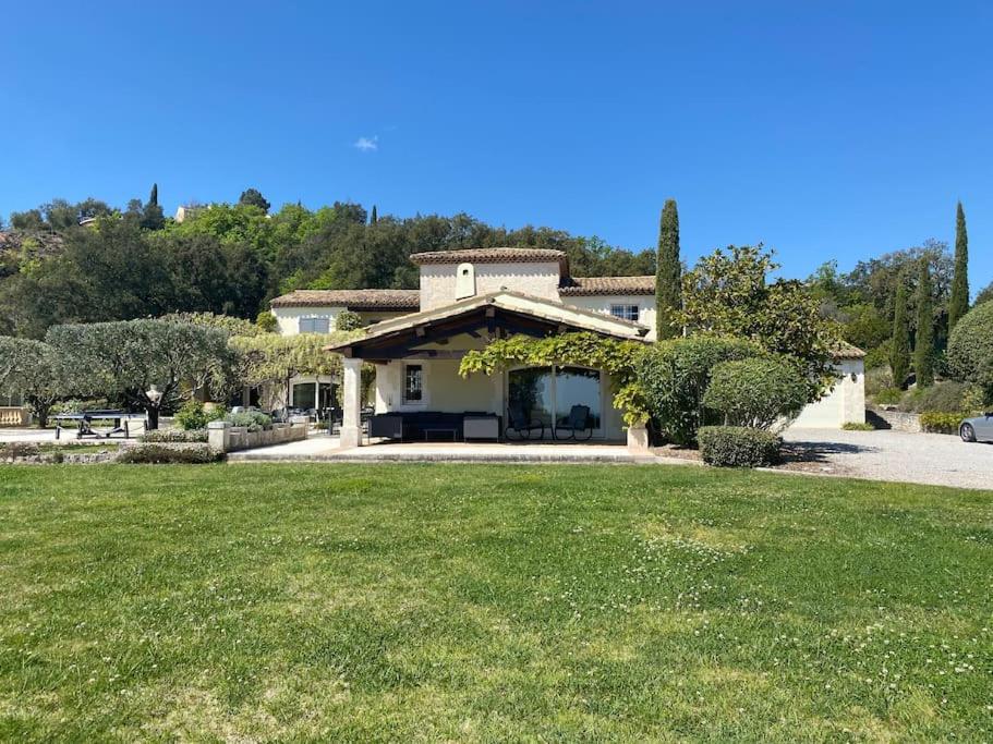 uma casa com um relvado verde em frente em Villa vue mer à côté de Cannes dans l'Esterel ! em LʼÉglise