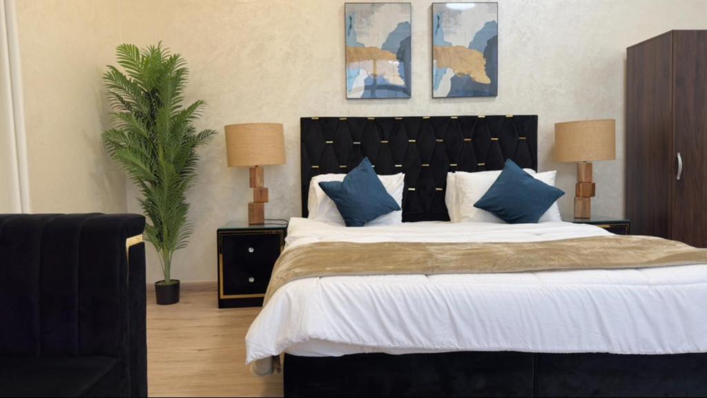 a bedroom with a large bed with blue pillows at sea breeze RAK in Ras al Khaimah