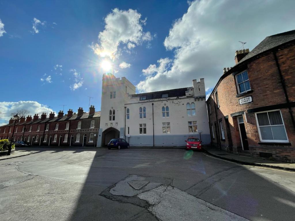 een groot wit gebouw met de zon in de lucht bij Chester Stays - Best Value Apartment with Free Parking in the heart of Chester in Chester