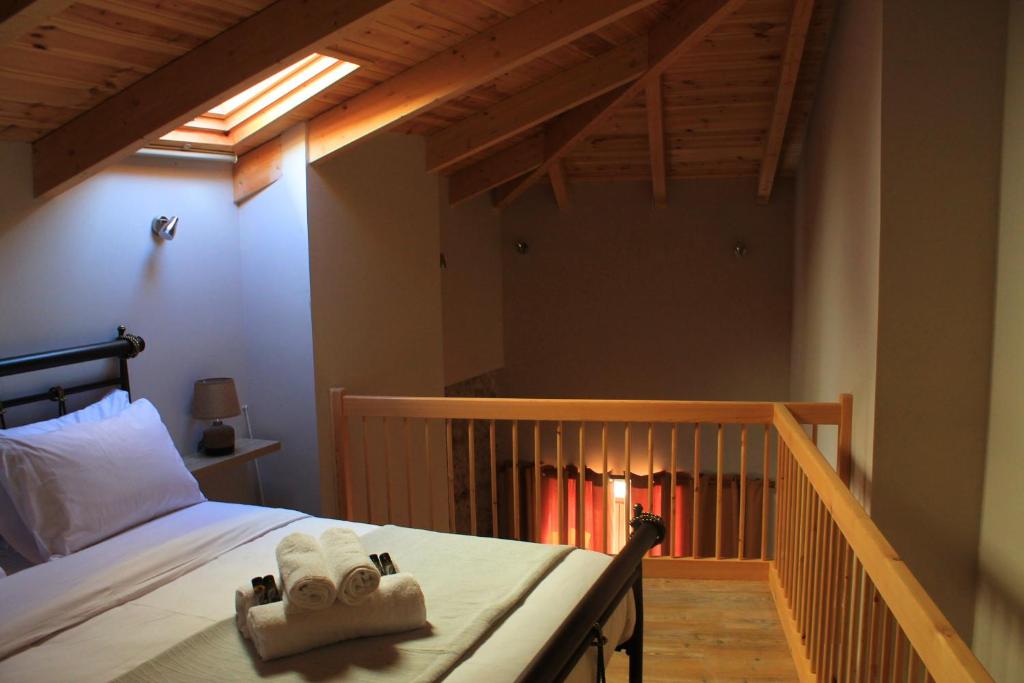 Δρυάδες Suites في أراخوفا: غرفة نوم عليها سرير وفوط