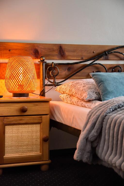 a bedroom with a bed and a lamp on a night stand at Willa Bartek in Zakopane