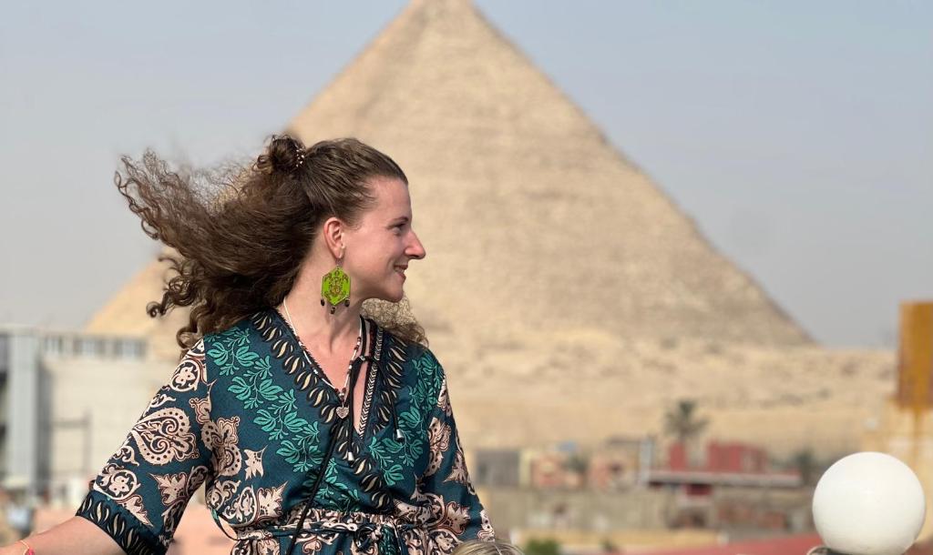 una mujer está parada frente a las pirámides en Pyramids moon view en El Cairo