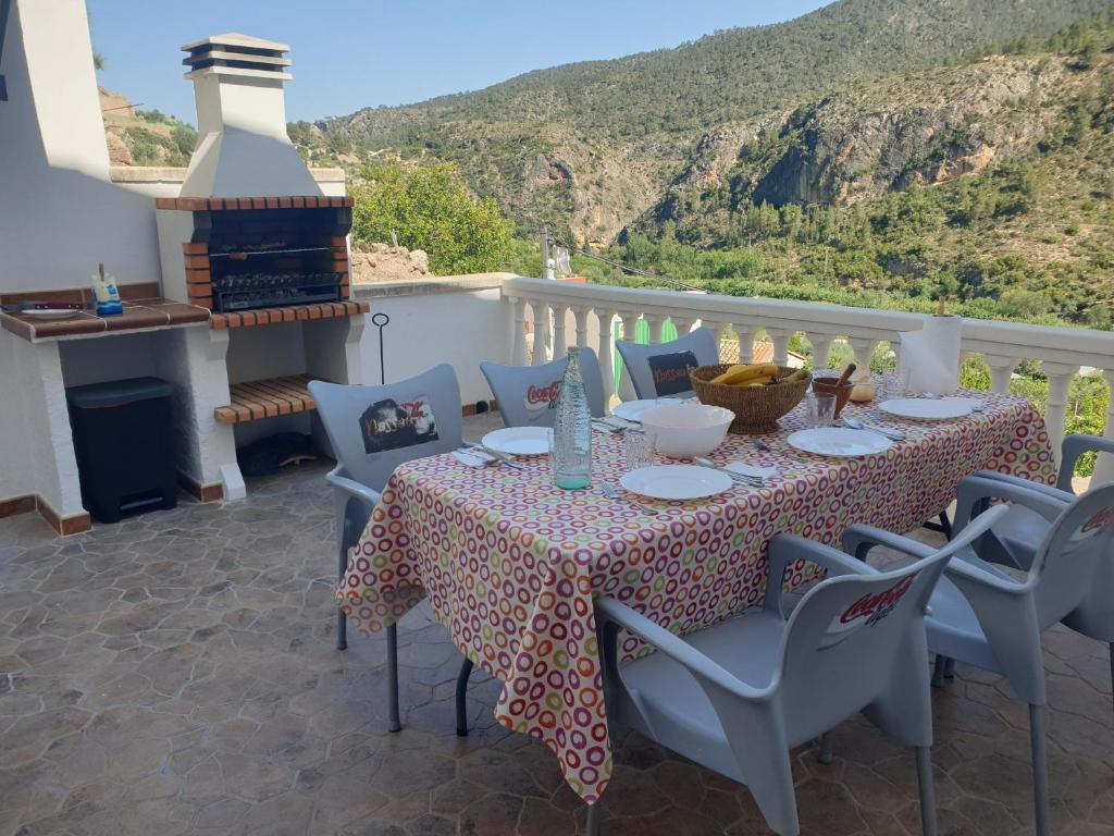 a table and chairs on a balcony with a fireplace at Casa Rural El Lobo in Ayna
