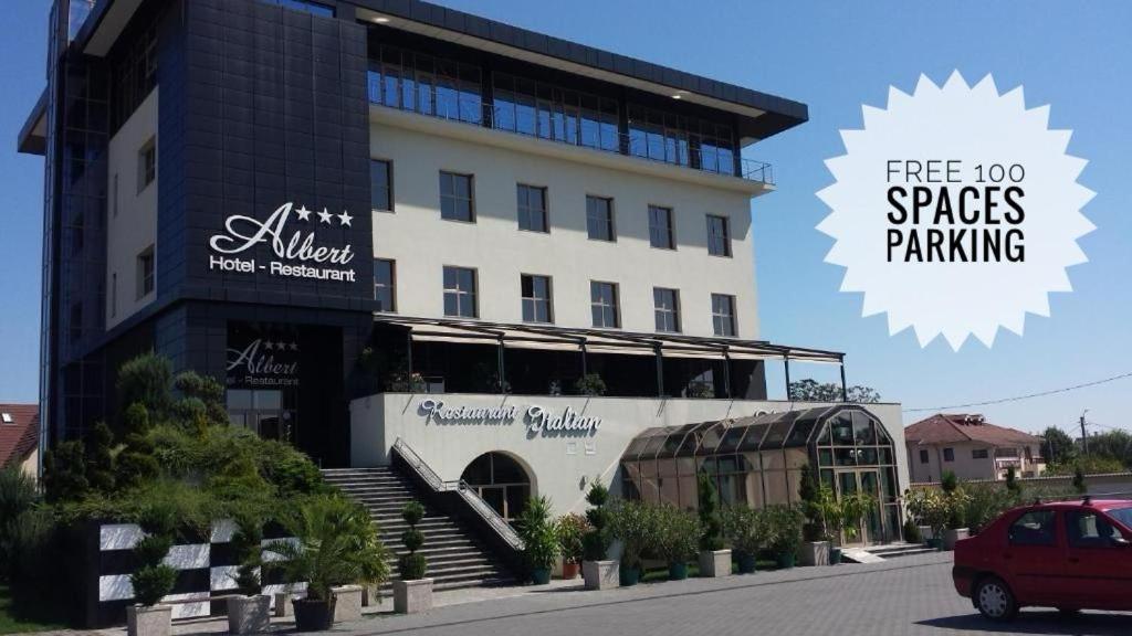 un bâtiment avec une voiture garée devant lui dans l'établissement Albert Hotel, à Ploieşti