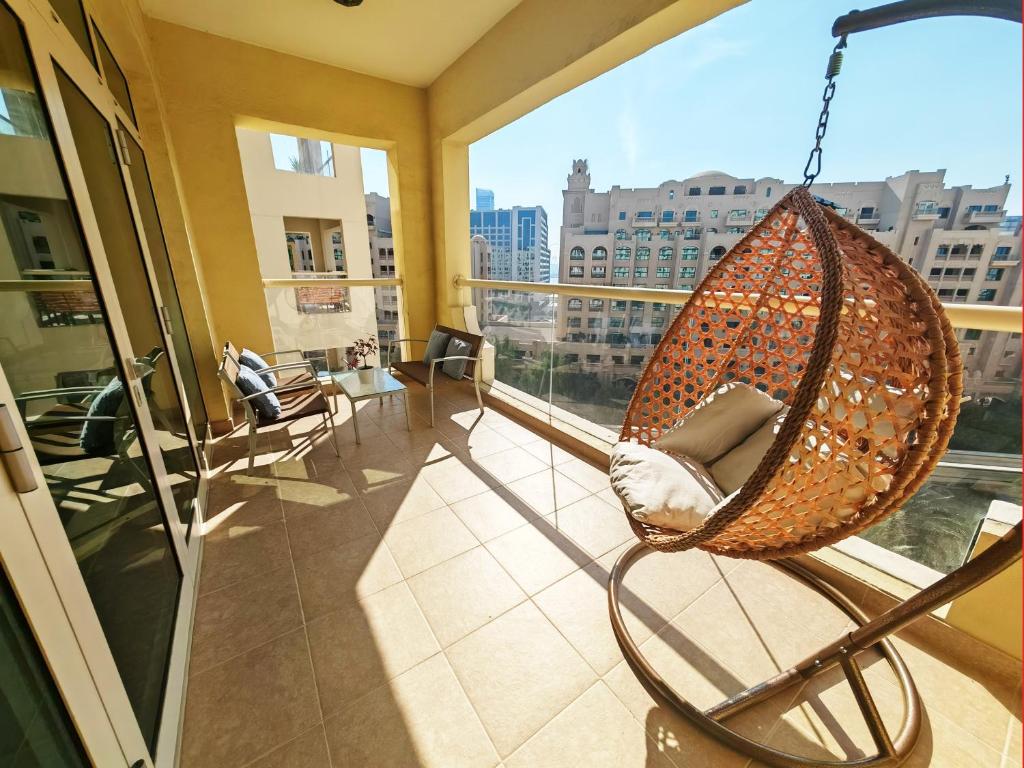 a hanging hammock in a room with a large window at Seaside Serenity Residence Elegant 1BR Escape in Palm Jumeirah by La Buena vida holiday homes in Dubai