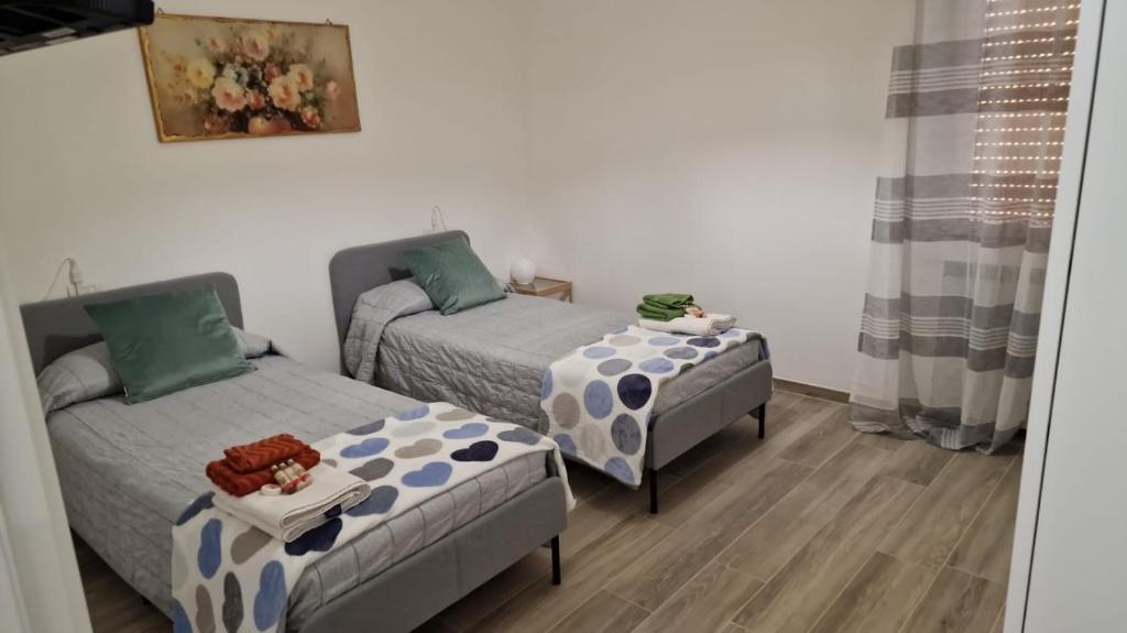 um pequeno quarto com 2 camas e uma mesa em Appartamento Violet - Parma em Parma