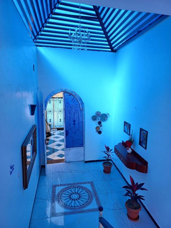 a blue room with a door and some plants at Villa Kaslan Apartments in Luxor