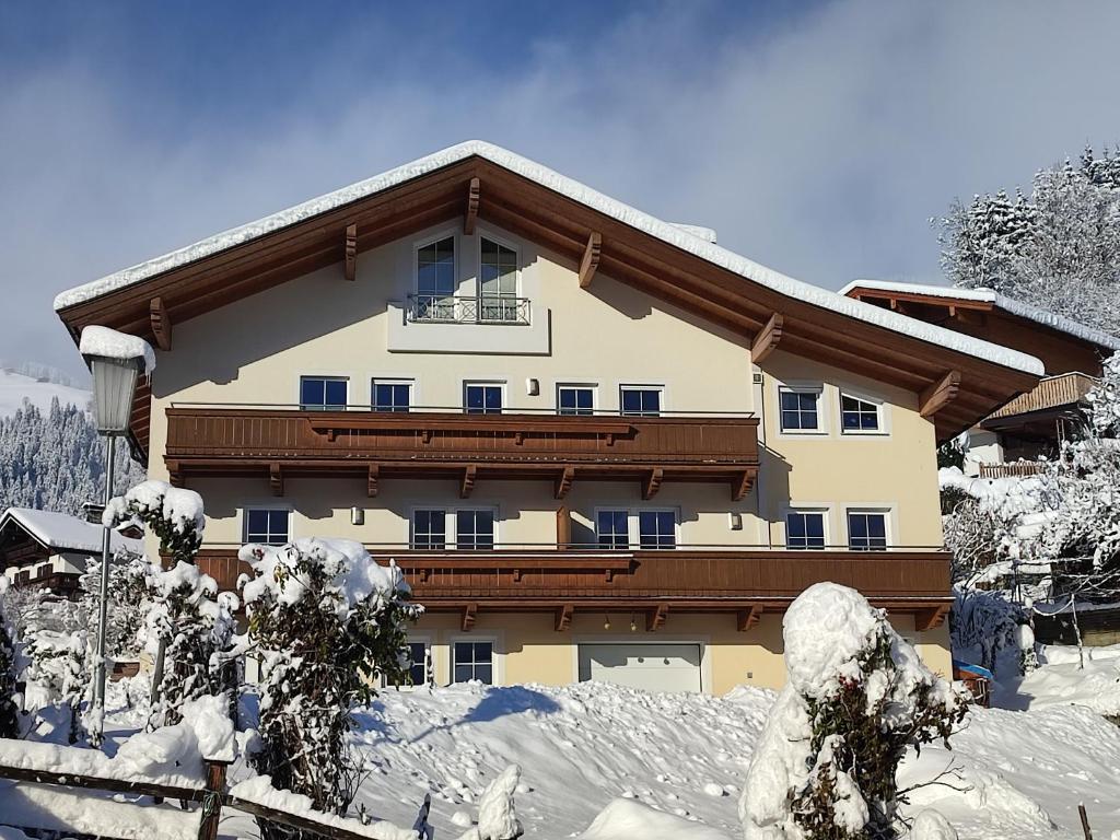 a large building with snow on the ground at Appartement Christine in Brixen im Thale
