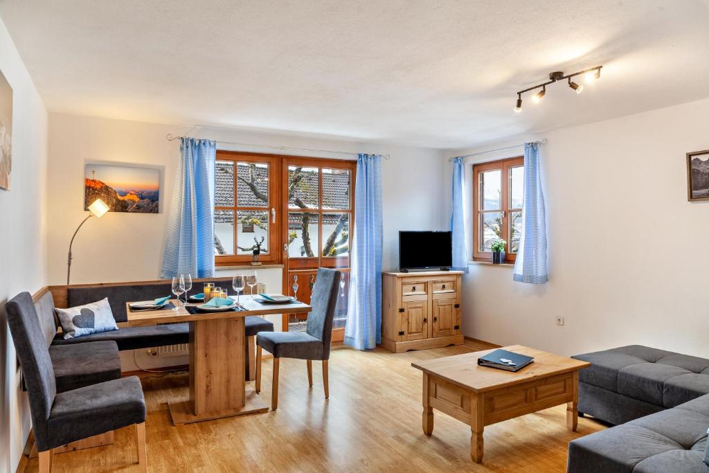 een woonkamer met een tafel en een bank bij Ferienwohnung Zugspitze in Farchant