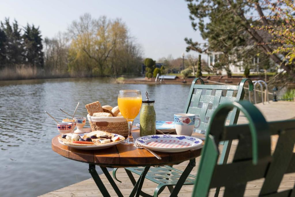 una mesa con comida y un vaso de zumo de naranja en Vegan B&B De Groene Mus, en Wervershoof