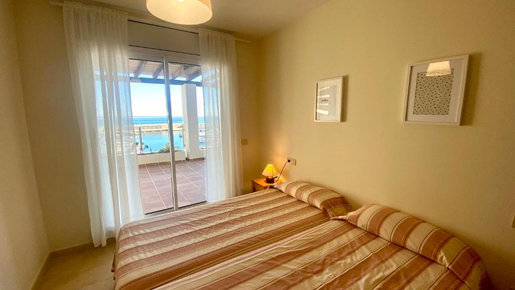 a bedroom with a bed with a view of the ocean at Residencial Marina de Port in L'Ametlla de Mar