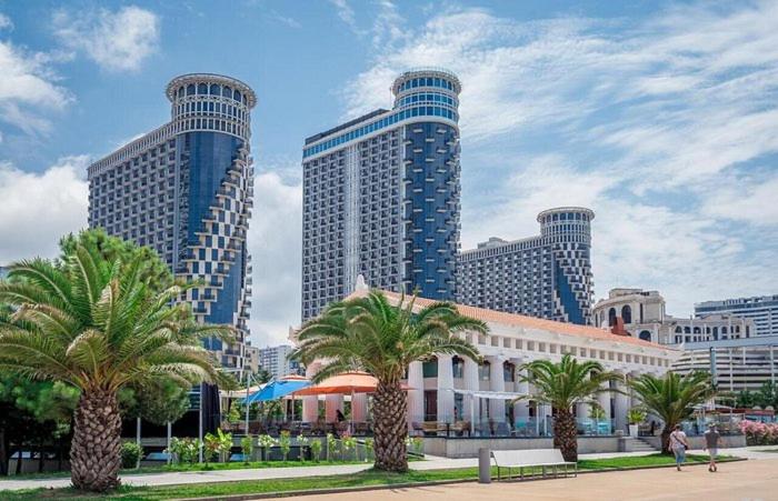 a city with palm trees and tall buildings at Orbi sea towers in Batumi