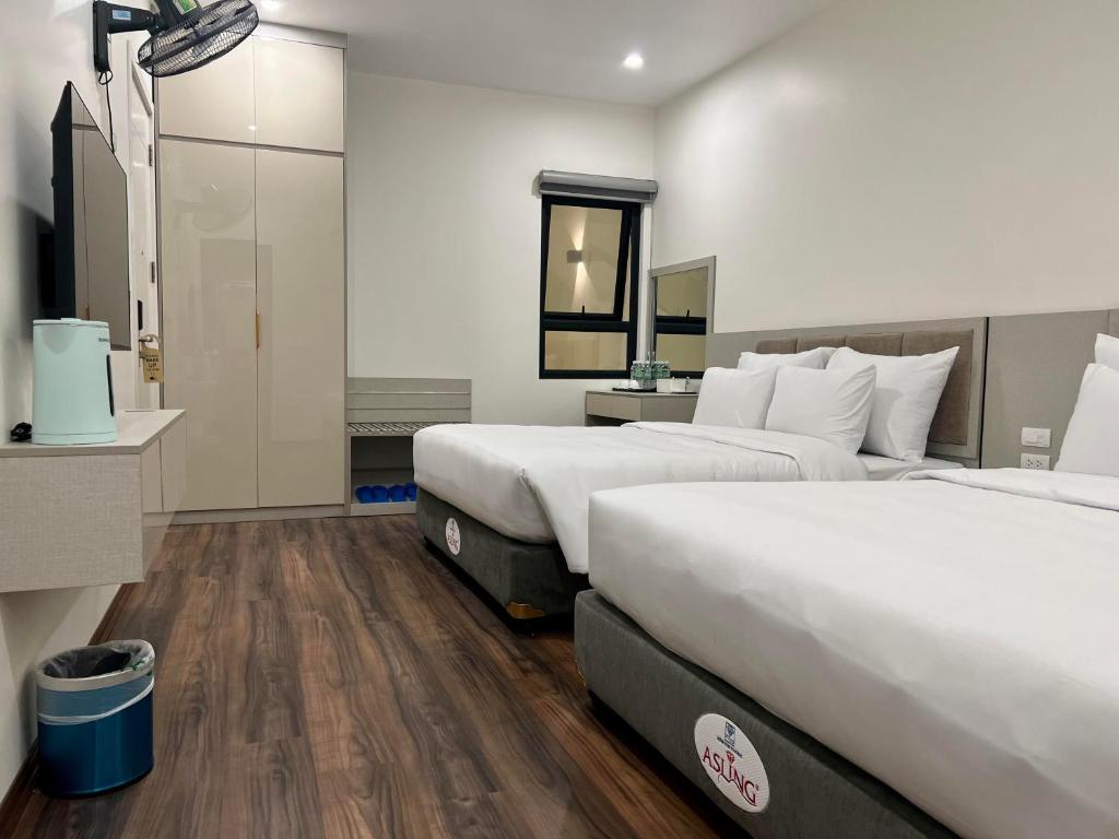 ein Hotelzimmer mit 2 Betten und einem Spiegel in der Unterkunft Grand Dragon Noi Bai Hotel in Hanoi