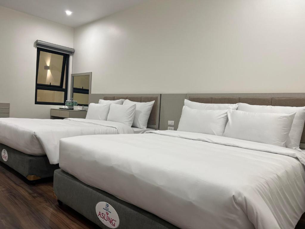 Postel nebo postele na pokoji v ubytování Grand Dragon Noi Bai Hotel